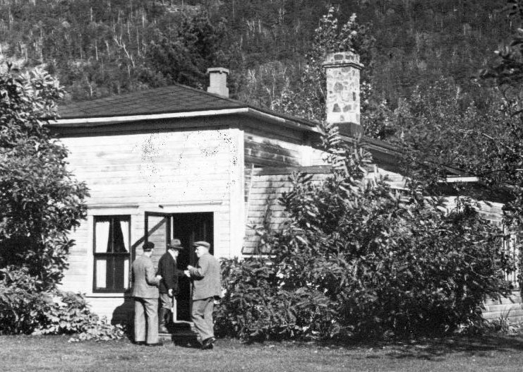 Photographie en noir et blanc de Correlieu, avec des invités qui entrent visiter Ozias Leduc.