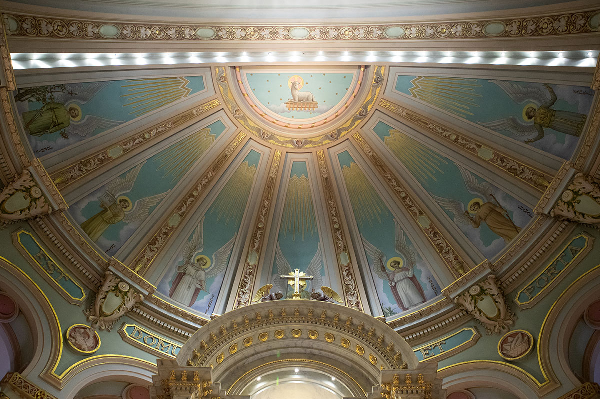 Voute décorée de l'Église montrant en haut l'Agneau Mystique, avec en périphérie semi-circulaire une série d'Archanges.