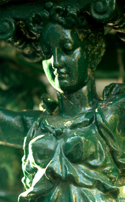 Détail d'une fontaine publique de la ville de Paris, représentant une figure féminine supportant au dessus de sa tête un bassin d'eau.