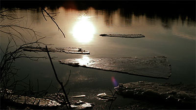 Scène de la vidéo représentant des fragments de glace flottant sur la rivière Richelieu, au soleil couchant.